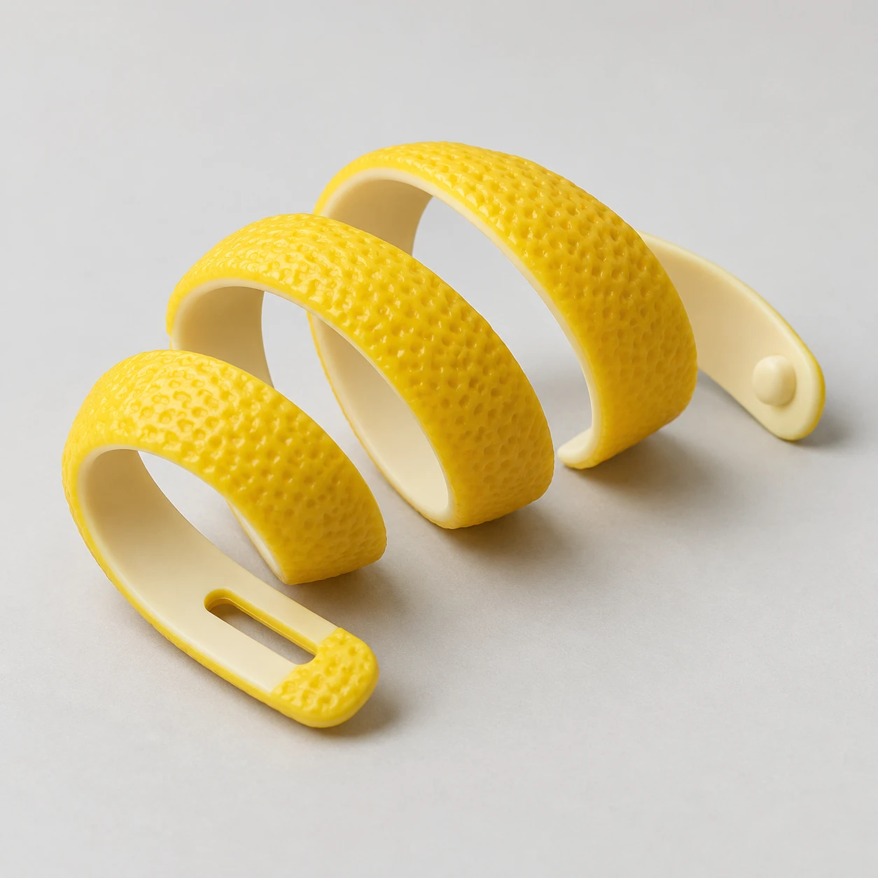 Yellow silicone cable wrap shaped like a curling lemon peel, with a fastening slot.